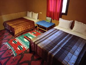 瓦尔扎扎特Bivouac Lot Of Stars的有两张床和一张桌子的酒店房间