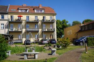 a playground in a park in front of a building at Apartmenthaus Am See in Rheinsberg +21 photos