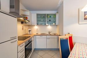 a small kitchen with white cabinets and a sink at Villa Mara Wohnung 3 in Baabe +10 photos