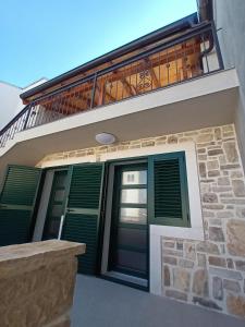a house with green doors and a balcony at Jacuzzi Haus in Posedarje