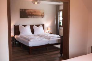 una camera da letto con un letto con lenzuola bianche e uno specchio di Haus Für 22 Personen Mit Außensauna Und Hottub a Dahlem