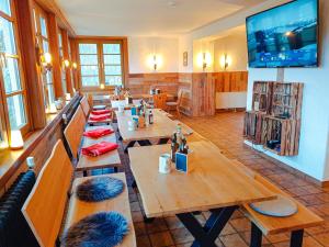 una sala da pranzo con tavoli in legno e TV a schermo piatto di Haus Für 22 Personen Mit Außensauna Und Hottub a Dahlem