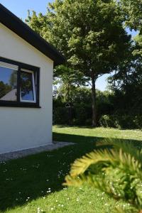een huis met een raam en een groene tuin bij Kleines Haus Mit Garten, Direkt Hinter Dem Deich in Baarland