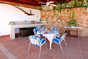 einen Tisch und Stühle in einem Zimmer mit einer Steinmauer in der Unterkunft Wunderschönes Landhaus mit Schwimmbad und absoluter Privatsphäre in Comares + 31 Fotos