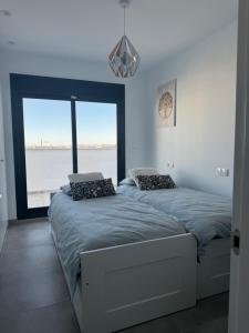 a bedroom with two beds and a large window at Santa Rosalía Lake and Life - INVBUILD ESTATES in Torre-Pacheco +40 photos