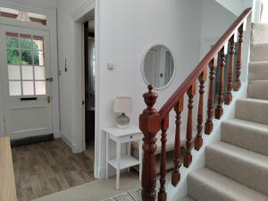 德里门Mulberry Lodge Guest Suite - luxurious accommodation on West Highland Way的走廊上设有楼梯,墙上有镜子