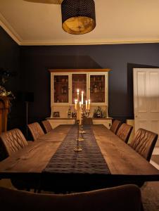 德里门Mulberry Lodge Guest Suite - luxurious accommodation on West Highland Way的用餐室配有带蜡烛和椅子的桌子 更多17张照片