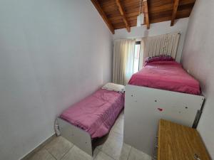 Un dormitorio pequeño con una cama individual. en Amplia casa en La Falda, en La Falda