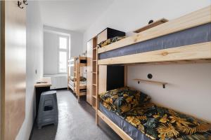 a room with two bunk beds and a desk at Najtańsze noclegi Piłsudskiego 93 in Łódź
