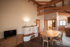 a kitchen and dining room with a table and a television at Ortnerhof in Gais