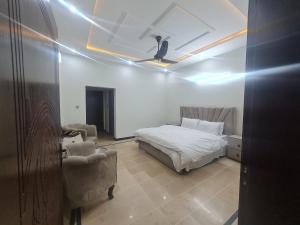 a bedroom with a bed and a chair in a room at Haven homes in Islamabad +2 photos