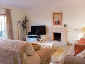 a living room with a couch and a fireplace at Villa Oasis Parque BY SWEET HOME in Portimão