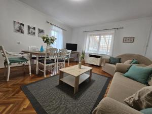 a living room with a couch and a table at Csobogós Vendégház Mályinka in Mályinka