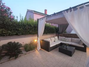 a patio with a white couch and a table at Villa Summer Escape In Barbat Mit Garten Und Aussicht in Barbat na Rabu +32 photos