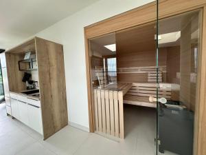 a kitchen with wooden cabinets and a glass wall at Hafen 15 - Ihre Ferienwohnung im Hafen am Geiseltalsee in Mücheln +19 photos