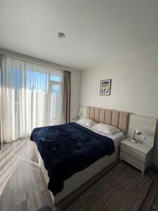 a bedroom with a large bed and a large window at Studio Near Beach & Boulevard in Adliye