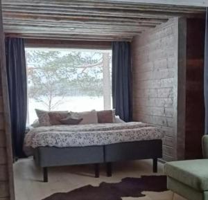 a bed in a room with a large window at Lapland Hygge in Rovaniemi