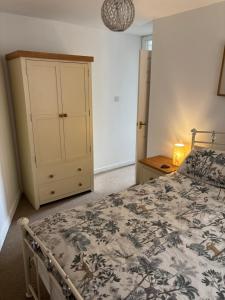 a bedroom with a bed with a dresser and a cabinet at Symonds Yat West Holiday Cottage 8 WRC with views of Yat Rock in Symonds Yat