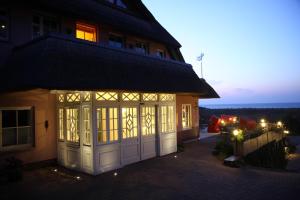Romantik Hotel Namenlos في ارنشوب: منزل به كراج في الليل مع تشغيل الأضواء