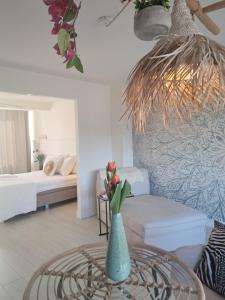 a living room with a vase with flowers on a table at Rembrandts beach view in Zandvoort