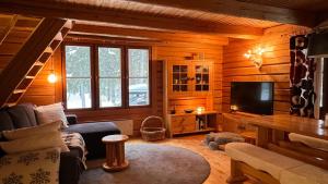 a living room with a couch and a television at Rukan Karhumökki in Ruka