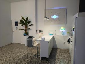 a white office with a desk and a potted plant at CAPSULE INN VALENCIA Hostel in Valencia +22 photos