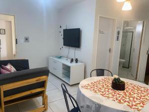 a living room with a table and a tv at Apartamento Studio 201 in Juazeiro