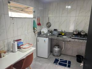 a small kitchen with a counter and a refrigerator at Pousada Vista das Pedras in Pancas