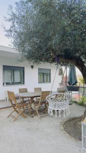 un patio avec une table et des chaises sous un arbre dans l'établissement Réveillon 2026 CASA LOS PADEL - Vitorino dos Piães, à Navio
