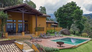 a house with a wooden deck and a swimming pool at Pousada A Rosa e o Rei in São Francisco Xavier