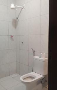 a white bathroom with a toilet and a shower at Sítio Jacutinga 2025 in Pacoti +12 photos