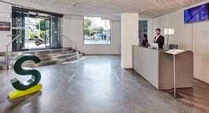 a man standing at a counter in a lobby with a letter s at Sercotel Amister Art Hotel Barcelona in Barcelona