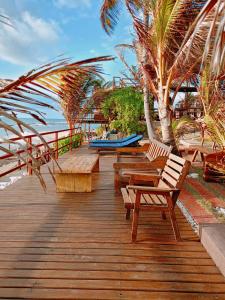 a wooden deck with benches and palm trees on the beach at Vila Bello Pontal in Coruripe