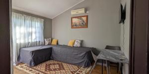 a small bedroom with a bed and a table at Koshys Haven at Kruger in Malelane