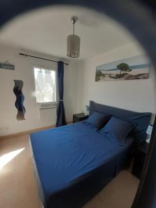 ein Schlafzimmer mit einem blauen Bett und einem Fenster in der Unterkunft Sous Le Soleil Des Alpilles in Mouriès
