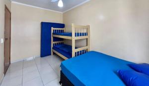 une chambre avec un lit bleu et une étagère dans l'établissement Cantinho do Churrasco - Varanda Gourmet a 60 mts praia, à Praia Grande 18 autres photos