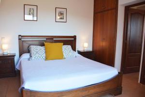 ein Schlafzimmer mit einem Bett mit einem gelben Kissen darauf in der Unterkunft Charming Traditional Sea View Home in Es Cana + 16 Fotos