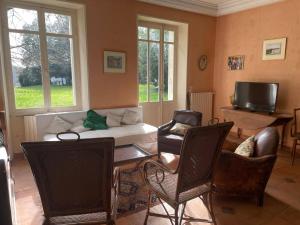 a living room with a couch and a table and chairs at Sorbède - Charmante maison pour 10 personnes in Montussan