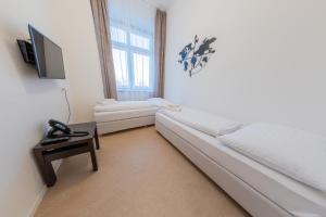 uma sala de estar com um sofá branco e uma TV em Hotel Granit Nová Polianka*** - klimatické kúpele em Vysoké Tatry