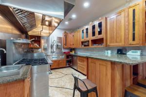 a kitchen with wooden cabinets and stainless steel appliances at Copano Bay Fishing Lodge in Lamar