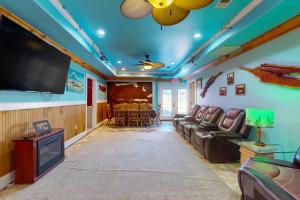 a living room with a couch and a flat screen tv at Copano Bay Fishing Lodge in Lamar