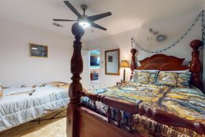 a bedroom with a wooden bed and a ceiling fan at Copano Bay Fishing Lodge in Lamar