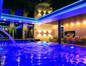 a swimming pool with blue lights in a building at DELF INN Adults Only in Świnoujście