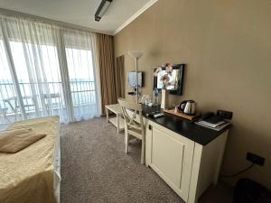 a hotel room with a bed and a desk with a television at Regina Maria Spa Design Hotel in Balchik