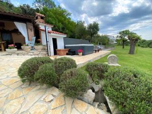 un giardino con cespugli di fronte a una casa di Tolles Ferienhaus In Supetarska Draga Mit Garten a Supetarska Draga