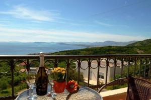 a table with wine bottles and flowers on a balcony at Strandnahe Ferienwohnung In Podstrana in Podstrana