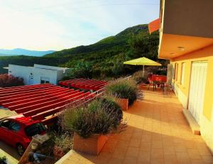 a patio with a red car and red tables and chairs at Strandnahe Ferienwohnung In Podstrana in Podstrana