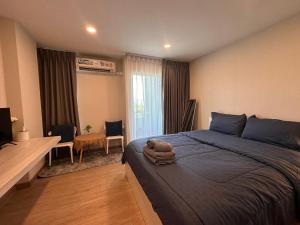 een slaapkamer met een bed, een bureau en een tafel bij AVALYN Room Plus II - East Ville in Ban Hua Khao Sammuk