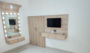 une télévision sur un mur à côté d'un miroir dans l'établissement Shree Ji Stays, à Fāzilka 11 autres photos