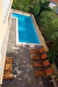 a swimming pool with a stone walkway leading to a swimming pool at Gästezimmer Tina 6 in Šilo